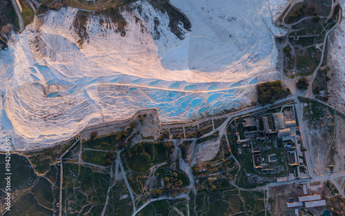Aerial drone view of the famous Pamukkale travertines and thermal pools in Denizli, Turkey, showing the white calcium terraces, natural formations, and scenic landscape from above.
