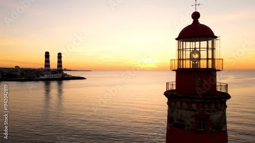 Coastal Lighthouse at Sunset - A Serene View of the Ocean and Sky.