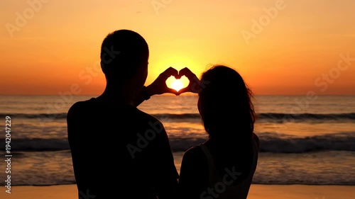 Romantic Couple Making Heart Shape at Sunset on Beach.