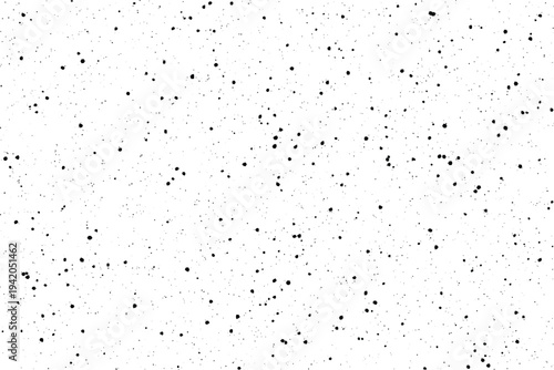 An expanse of white is covered with a uniform scattering of tiny black specks resembling fine dust or a grainy film