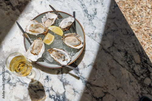 Fresh oysters on ice with champagne in sunlight