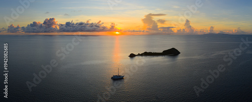 Konstfotografi A serene sunrise silhouettes a small island in the Vatu-i-ra seascape in Fiji