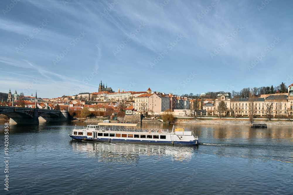 Fototapeta premium Vltava river cruise boat passes Prague Castle and St Vitus Cathedral skyline
