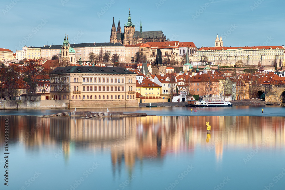 Fototapeta premium Prague Castle and St Vitus Cathedral above Vltava River with calm reflective water
