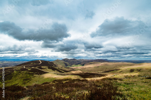View to Pentlands - Scottish landscape with hills covered by grass and moss. Low sky with dramatic clouds.