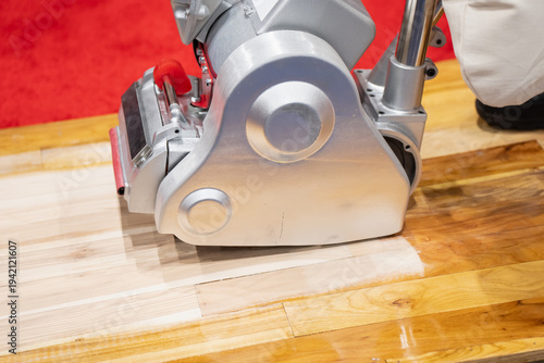 Tableau sur toile Floor sanding machine smoothing wooden boards during surface refinishing work, i