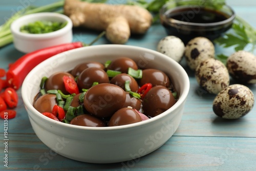 Foto Pickled quail eggs and ingredients on blue wooden table, closeup