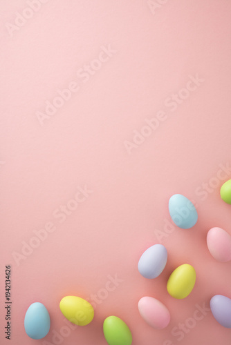 Vertical Easter background with pastel eggs at the bottom on pink. Minimalist style, copy space.