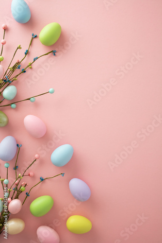 Vertical Easter flat lay with pastel eggs and spring flower branches on pink. Copy space on right.