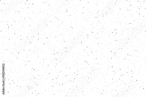 A visually subtle pattern of many small black dots scattered randomly across a bright white surface