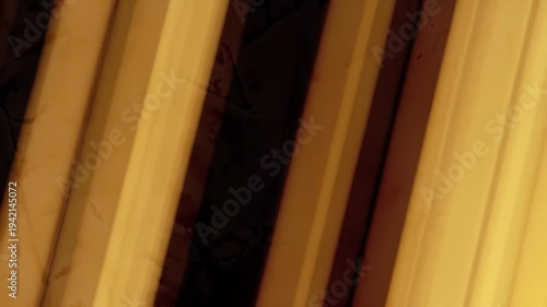 Diagonal golden light beams streak across a dark, abstract background.