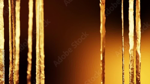Close-up view of icicles with a warm glowing background.