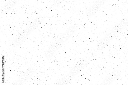 Numerous tiny black dots are scattered randomly across a bright clean white surface
