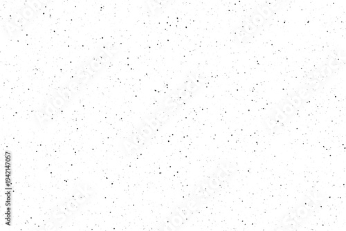 Numerous tiny black dots are scattered randomly across a bright clean white surface