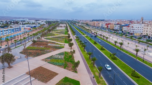 Fotografie Aerial drone view of a newly renovated modern avenue featuring green public parks, sports courts, palm trees, and urban infrastructure in Agadir, Morocco