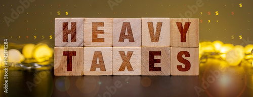Foto Heavy Taxes Message on Wooden Blocks Representing High Corporate Tax Burden and