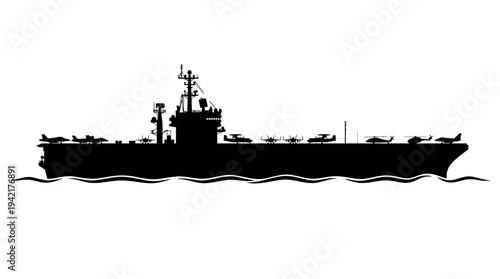 Silhouette of a large aircraft carrier sailing on the ocean waves