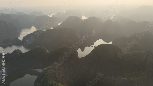 Tableau sur toile Beautiful sunrise over Ha Long Bay with limestone karst islands rising from the emerald water, traditional boats sailing between the cliffs in northern Vietnam