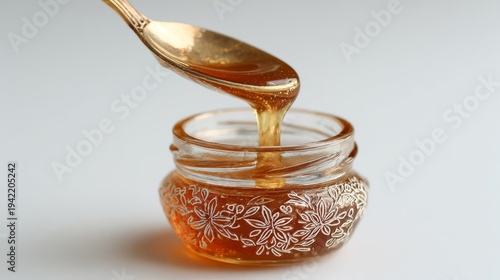 Golden Honey Poured From Spoon Into Small Jar