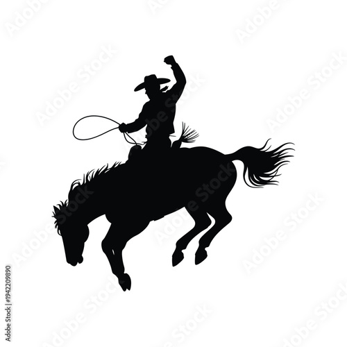 Silhouette of a cowboy on a bucking horse with a lasso