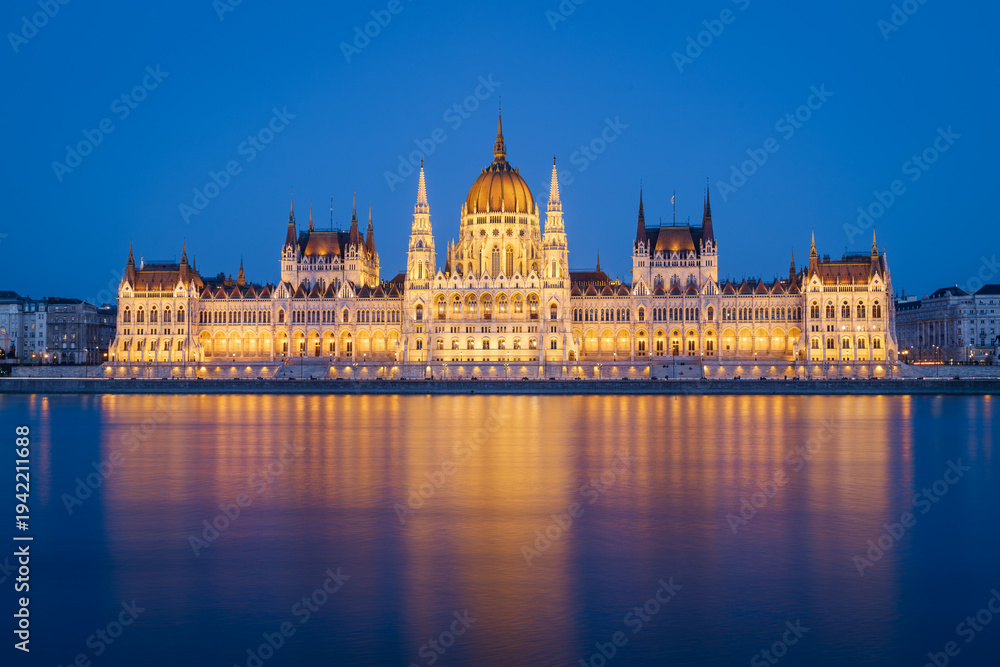 Fototapeta premium The Budapest Parliament building at nightfall on the Danube river bank