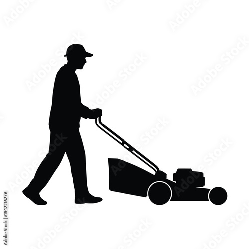 Silhouette of a man mowing a lawn with a push mower