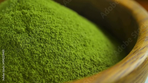 Organic Green Matcha Tea powder in wood bowl.