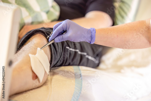 Instructor showing correct wound disinfection method with sterile gauze and forceps during nursing education