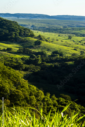 Stunning cliff formation in a lush green valley in Sao Paulo state. A landmark representing the region unique geology, farm pastures and the beauty of the Atlantic Forest biome