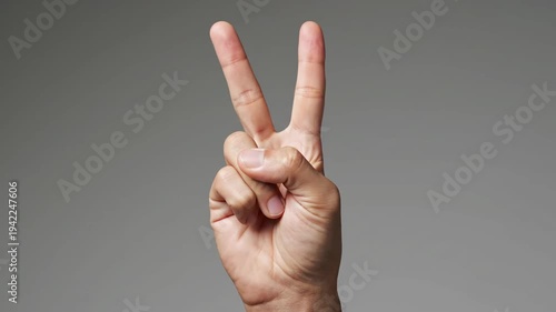 Hand Showing Peace Sign Gesture Closeup.