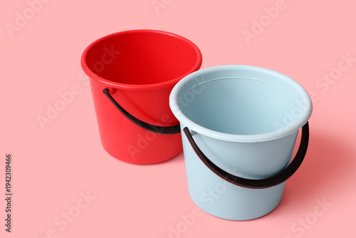 Plastic buckets on pink bac...
