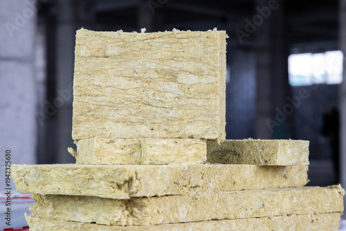 Professional rock wool insulation slabs stacked on a construction site, ready for wall or roof installation.