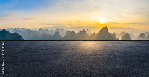 Low angle view of an empty asphalt road surface with karst mountains at sunrise, Guilin, China.