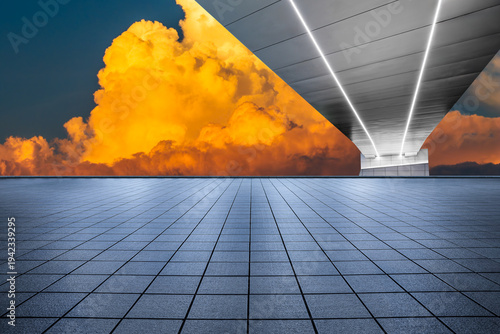 Empty modern city plaza and sleek bridge under a dramatic golden sunset sky.