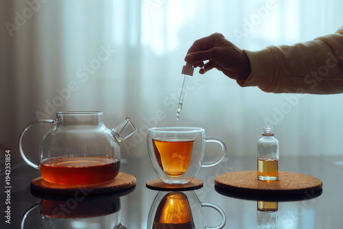 Hand Adding Sweetener with Pipette into Tea Cup
Person using sugar alternatives for sweetening herbal drinks 