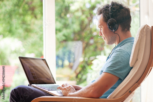 procrastination, man in headphones watching videos online on laptop at home