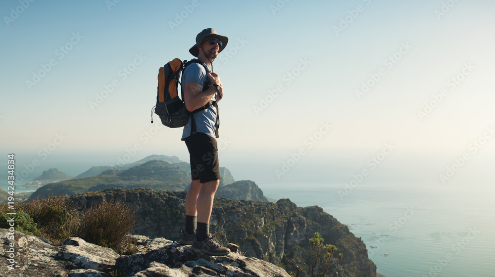 Obraz premium View, man and hiking with backpack on cliff for travel adventure, tourism or nature appreciation. Space, mature person and sightseeing on mountain top for trekking break, backpacking or explore ocean