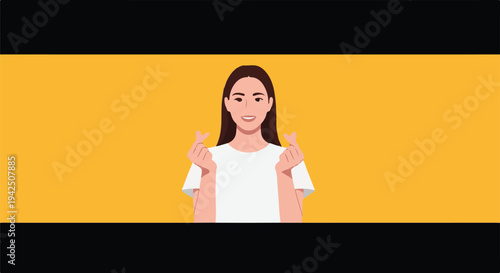 Young woman making a finger heart gesture and smiling gently, symbolizing love and affection against a vibrant yellow background