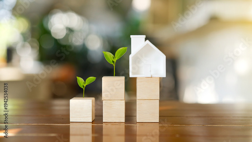 Foto white house model on wooden blocks with small green plants growing for sustainable real estate investment and property financial growth concept