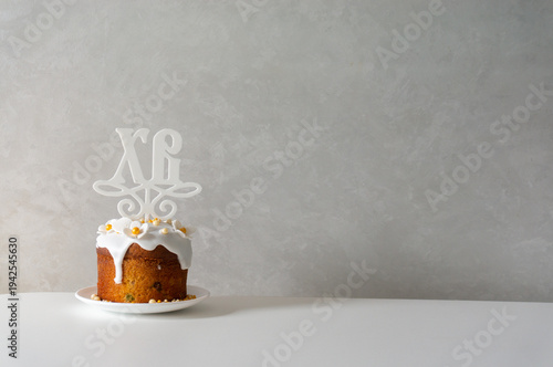 Happy Easter. Easter greeting background. Easter cake decorated with flowers and icing on a white table.