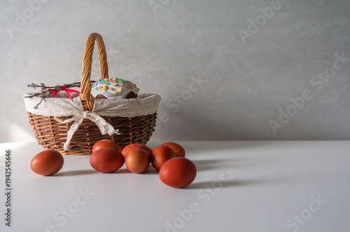 Happy Easter, Easter cake in a basket and painted eggs on a white table for your holiday decoration. Space for text.