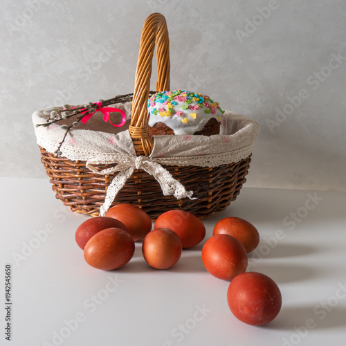 Happy Easter, Easter cake in a basket and painted eggs on a white table for your holiday decoration. Space for text.