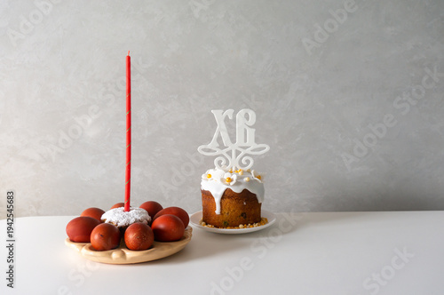 Happy Easter. Easter greeting background. Easter eggs and red candle. Easter cake decorated with flowers. Background with space for text.
