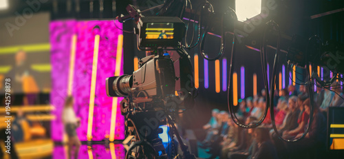 Professional broadcast camera in modern TV studio with neon lights and copy space