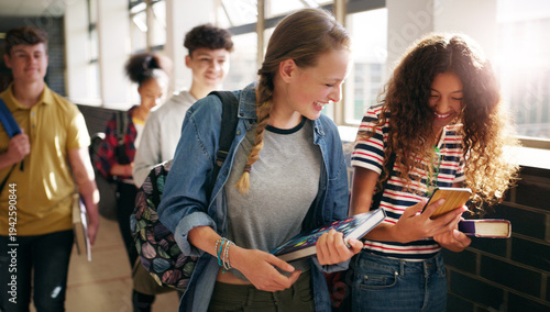 Fotografie Hallway, friends and teenager with phone at school, academy gossip forum and education joke for laugh