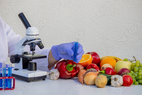 Scientist testing food quality of fresh vegetables and fruits using microscope