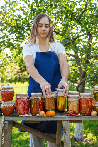 woman canning tomatoes cucumbers vegetables on the background of nature. Selective focus