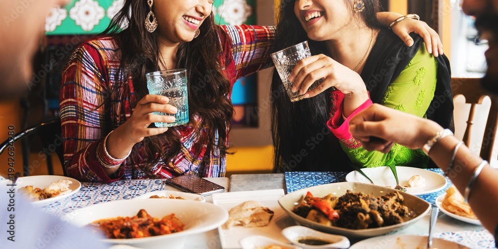 Ταπετσαρία Two Indian women joyfully share a meal, laughing and toasting with drinks