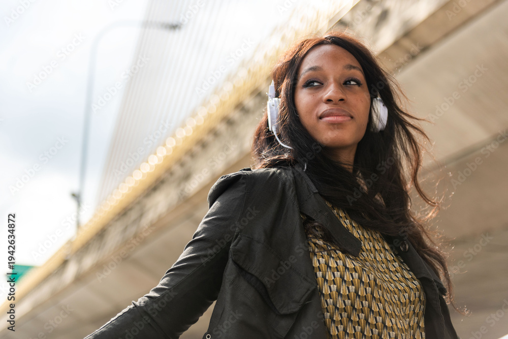 Obraz premium Confident woman enjoying music outdoors.