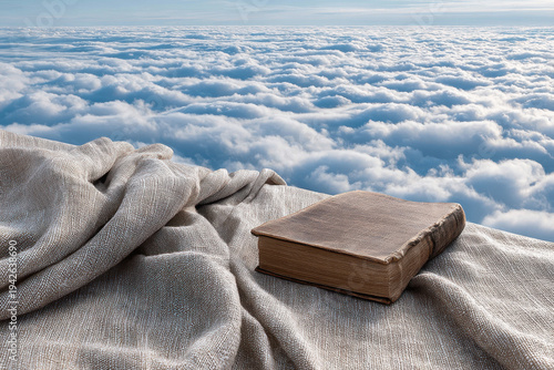 book with bookmark rests elegantly on flaxen fabric illuminated by soft glow of morning sunlight